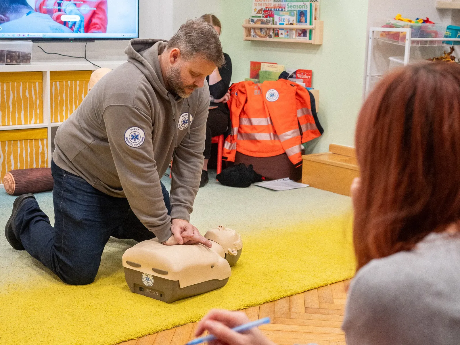 A Handprints staff member practicing CPR during first-aid training
